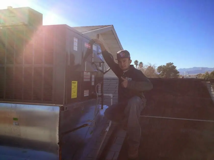 HVAC technician performing HVAC Inspection on a rooftop unit in Yelm